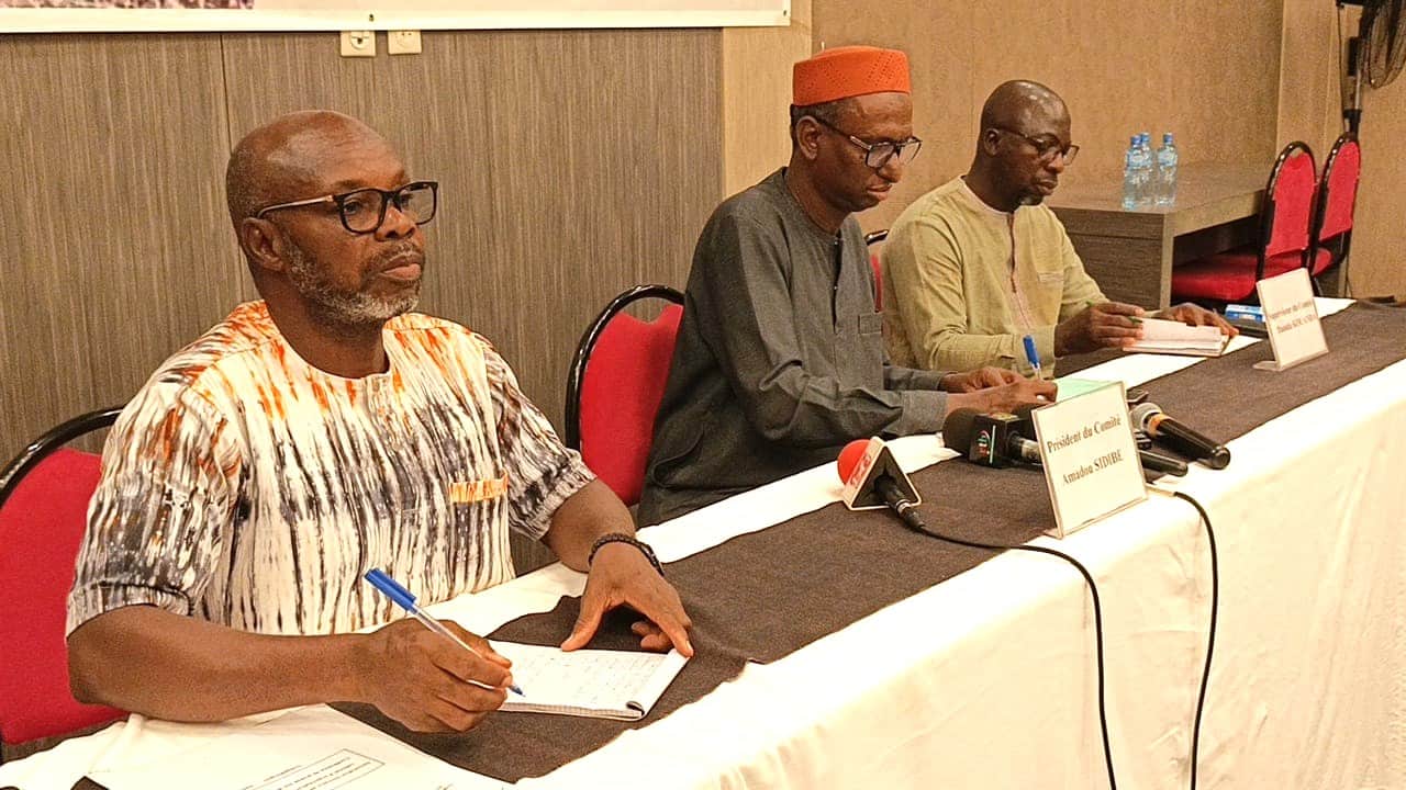 Trois hommes lors d’une conférence de presse